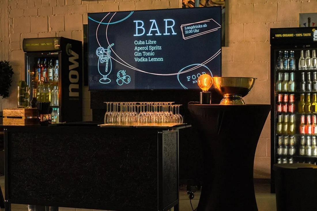 Mobile Bar mit Gläsern, Kühlschränken und Bildschirm mit Getränkekarte