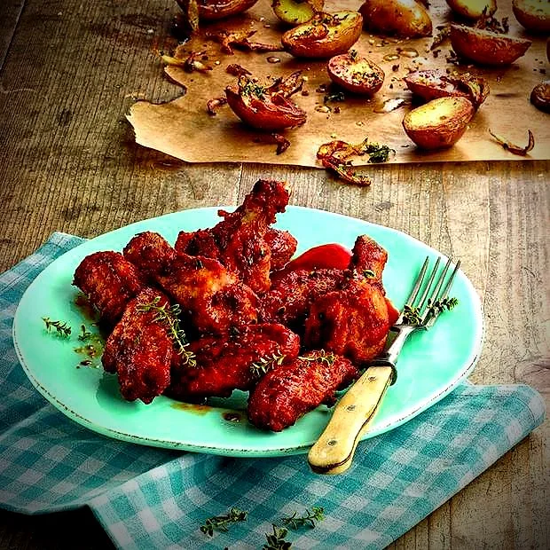 Glasierte Chicken Wings auf einem türkisfarbenen Teller